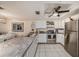 Well-lit kitchen boasts white cabinets, neutral countertops, stainless steel appliances, and tiled floor at 12924 Gulf Blvd # 110, St Petersburg, FL 33708