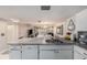 View of the kitchen's sink and cabinetry with open access to the bright living and dining area at 12924 Gulf Blvd # 110, St Petersburg, FL 33708