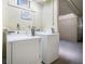 Laundry room with two new white washing machines against a textured wall, offering convenience for residents at 12924 Gulf Blvd # 110, St Petersburg, FL 33708