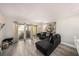 Inviting living room with wood floors, balcony access and modern black sectional couch at 12924 Gulf Blvd # 110, St Petersburg, FL 33708