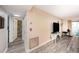 Hallway leading to the living room and bathroom featuring wood-style floors and neutral walls at 12924 Gulf Blvd # 110, St Petersburg, FL 33708