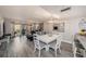 Open-concept living area with dining table, balcony access, modern decor, and tile flooring at 12924 Gulf Blvd # 110, St Petersburg, FL 33708