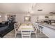 Open living space with a large couch, modern artwork, and dining area leading to the kitchen at 12924 Gulf Blvd # 110, St Petersburg, FL 33708