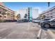Exterior view of parking lot at the property with several vehicles under a clear blue sky at 12924 Gulf Blvd # 110, St Petersburg, FL 33708