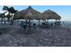 Relaxing community tiki huts offer shade and seating near the beach and pool area at 12924 Gulf Blvd # 110, St Petersburg, FL 33708