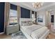 Well-lit bedroom with a large bed, stylish furnishings, and ample natural light from two windows at 15539 Stuart Cir, Port Charlotte, FL 33981