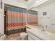 Cozy bathroom with a colorful shower curtain, a functional sink, and ample mirror space at 16143 Rambling Vine E Dr, Tampa, FL 33624