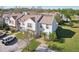 Well-maintained townhouses with manicured lawns, mature trees, and convenient parking spaces creating curb appeal at 16143 Rambling Vine E Dr, Tampa, FL 33624