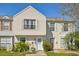 Charming two-story townhouse featuring neutral siding, white trim and a well-manicured front yard with lush landscaping at 16143 Rambling Vine E Dr, Tampa, FL 33624