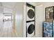 Hallway with closet featuring a stacked washer and dryer set, maximizing space and convenience at 16143 Rambling Vine E Dr, Tampa, FL 33624