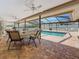 Inviting screened-in patio with dining set overlooking a refreshing outdoor swimming pool at 1664 Ridge Top Way, Clearwater, FL 33765