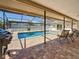 Inviting screened-in patio with outdoor grill overlooking a refreshing outdoor swimming pool at 1664 Ridge Top Way, Clearwater, FL 33765