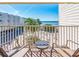 Balcony view overlooking the ocean, palm trees, and beachfront property with seating area at 2506 N Rocky Point Dr # 358, Tampa, FL 33607