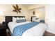 Bedroom with a large mirror, side table, bed with blue accents and a decorative leaf at 2506 N Rocky Point Dr # 358, Tampa, FL 33607
