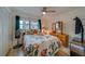 Cozy bedroom showcasing a floral-patterned bedspread, wood-look floors, and a ceiling fan at 2650 Countryside Blvd # F209, Clearwater, FL 33761
