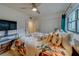 Bright bedroom with a large window, closet, ceiling fan, and comfortable floral-patterned bedding at 2650 Countryside Blvd # F209, Clearwater, FL 33761