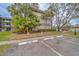Exterior view of the complex with palm trees and available parking spaces at 2650 Countryside Blvd # F209, Clearwater, FL 33761