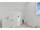 Bright laundry room featuring a sink, shelf, and tile flooring for efficient chores at 37252 Clinch Cir, Zephyrhills, FL 33540