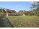 Large, grassy backyard with a partial fence, a shed, and mature trees at 404 Craft Rd, Brandon, FL 33511