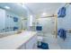 Charming bathroom featuring gold fixtures, white vanity, and tiled shower with glass doors at 4450 Gulf Blvd # 303, St Pete Beach, FL 33706
