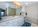 Spacious bathroom featuring white cabinets, a granite countertop, and an expansive mirror at 4450 Gulf Blvd # 303, St Pete Beach, FL 33706