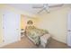 Cozy bedroom featuring a ceiling fan, neutral carpet, decorative wall art, and a comfortable bed with a patterned bedspread at 4450 Gulf Blvd # 303, St Pete Beach, FL 33706