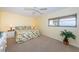 Cozy bedroom with a tropical-themed comforter, neutral carpet, and ample natural light at 4450 Gulf Blvd # 303, St Pete Beach, FL 33706