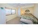 Bright bedroom with a tropical-themed comforter, natural light, and coastal views at 4450 Gulf Blvd # 303, St Pete Beach, FL 33706