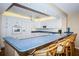 Bright kitchen features white cabinetry, blue countertops, and bar-style seating, creating an inviting space at 4450 Gulf Blvd # 303, St Pete Beach, FL 33706