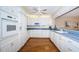 Bright kitchen with white cabinetry, blue countertops, and hardwood floors at 4450 Gulf Blvd # 303, St Pete Beach, FL 33706
