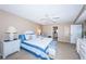 Cozy main bedroom with nautical-themed decor, complemented by a ceiling fan and bedside lamps at 4450 Gulf Blvd # 303, St Pete Beach, FL 33706