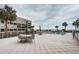 Comfortable patio area featuring outdoor seating with ocean views and lush palm trees, perfect for relaxed gatherings at 4450 Gulf Blvd # 303, St Pete Beach, FL 33706