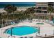 Beautiful pool area with lounge chairs, tables, and a view of the beach and ocean at 4450 Gulf Blvd # 303, St Pete Beach, FL 33706