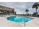 Condo complex pool overlooking the ocean complete with lounge chairs and tables at 4450 Gulf Blvd # 303, St Pete Beach, FL 33706