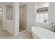 Bright bathroom features freestanding tub, tiled walk-in shower, and neutral color palette at 4535 Foley Grove Dr, Valrico, FL 33596