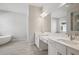 A Primary bathroom featuring dual sinks, a tub, and tile flooring at 4535 Foley Grove Dr, Valrico, FL 33596