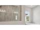 A modern shower room featuring tile, a glass enclosure, and a separate tub at 4535 Foley Grove Dr, Valrico, FL 33596