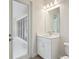 A well-lit bathroom with a single sink, a large mirror, and an adjacent door at 4535 Foley Grove Dr, Valrico, FL 33596