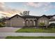 Stunning single-story home featuring a well-manicured lawn, arched windows and doorway, and a spacious three-car garage at 4535 Foley Grove Dr, Valrico, FL 33596