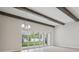 Living area with tiled floor, beamed ceiling and large sliding doors showcasing outdoor view at 4535 Foley Grove Dr, Valrico, FL 33596
