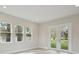 An empty living room, featuring a large window, a glass door, and hard surface flooring at 4535 Foley Grove Dr, Valrico, FL 33596