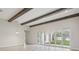 Bright living room has beamed ceiling, tiled floors, view of back yard and modern chandelier at 4535 Foley Grove Dr, Valrico, FL 33596