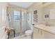 Bathroom featuring a glass enclosed shower, white tiled walls, and an adjacent vanity with decorative framed mirror at 4579 Del Sol S Blvd, Sarasota, FL 34243