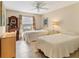 Bedroom featuring two twin beds, light walls, ceiling fan, and window with blinds at 4579 Del Sol S Blvd, Sarasota, FL 34243