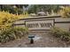 Community sign for Griffon Woods with lush landscaping and a glimpse of neighborhood homes in the background at 4579 Del Sol S Blvd, Sarasota, FL 34243
