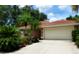 Charming single-story home featuring a barrel tile roof, lush landscaping, and a well-maintained two-car garage at 4579 Del Sol S Blvd, Sarasota, FL 34243
