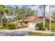 Charming home exterior with a tile roof, lush landscaping, and a two-car garage at 4579 Del Sol S Blvd, Sarasota, FL 34243