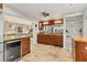 Open kitchen with wood cabinets, granite counters, stainless fridge, tile floors, with an open view to the living room at 4579 Del Sol S Blvd, Sarasota, FL 34243