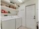 Laundry room featuring a white washer and dryer, storage shelves and a door at 4579 Del Sol S Blvd, Sarasota, FL 34243
