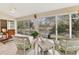 Bright sunroom featuring water views, tile flooring, and comfortable wicker seating at 4579 Del Sol S Blvd, Sarasota, FL 34243
